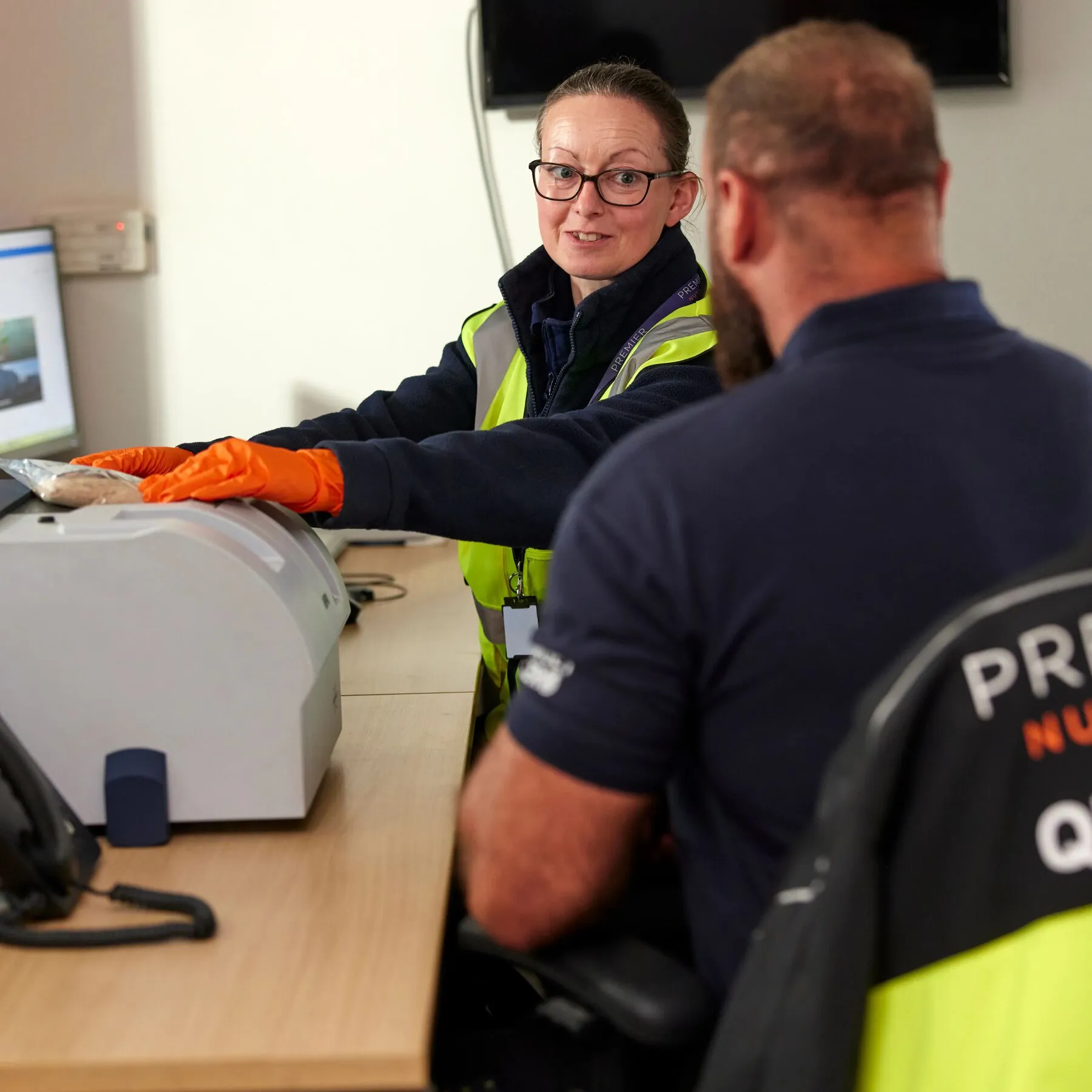 A quality control technician speaks to the site manager while testing ingredient samples at Premier Nutrition, Fradley, UK
